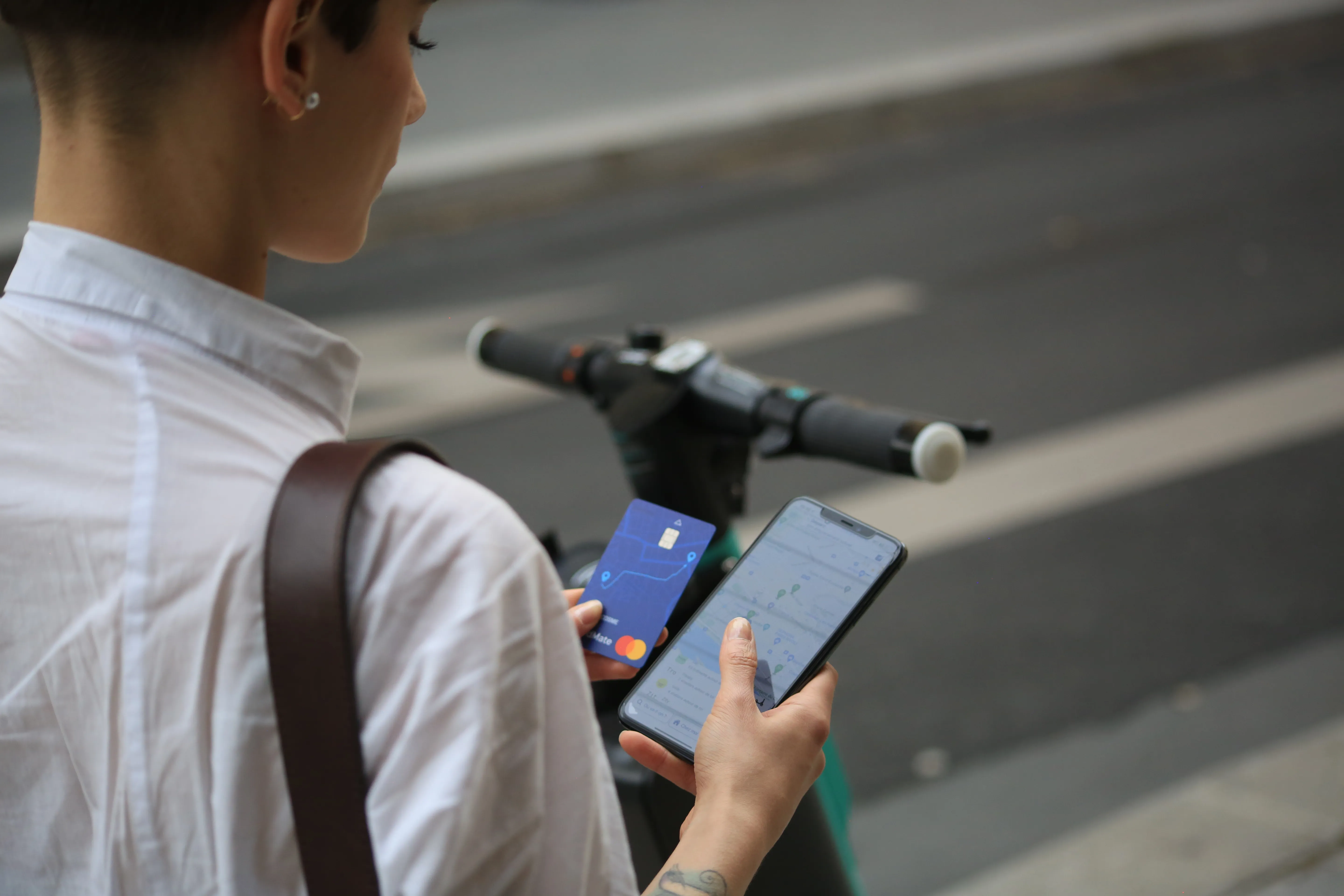 Une utilisatrice utilisant l'application RoadMate et sa carte RoadMate pour choisir une solution de mobilité