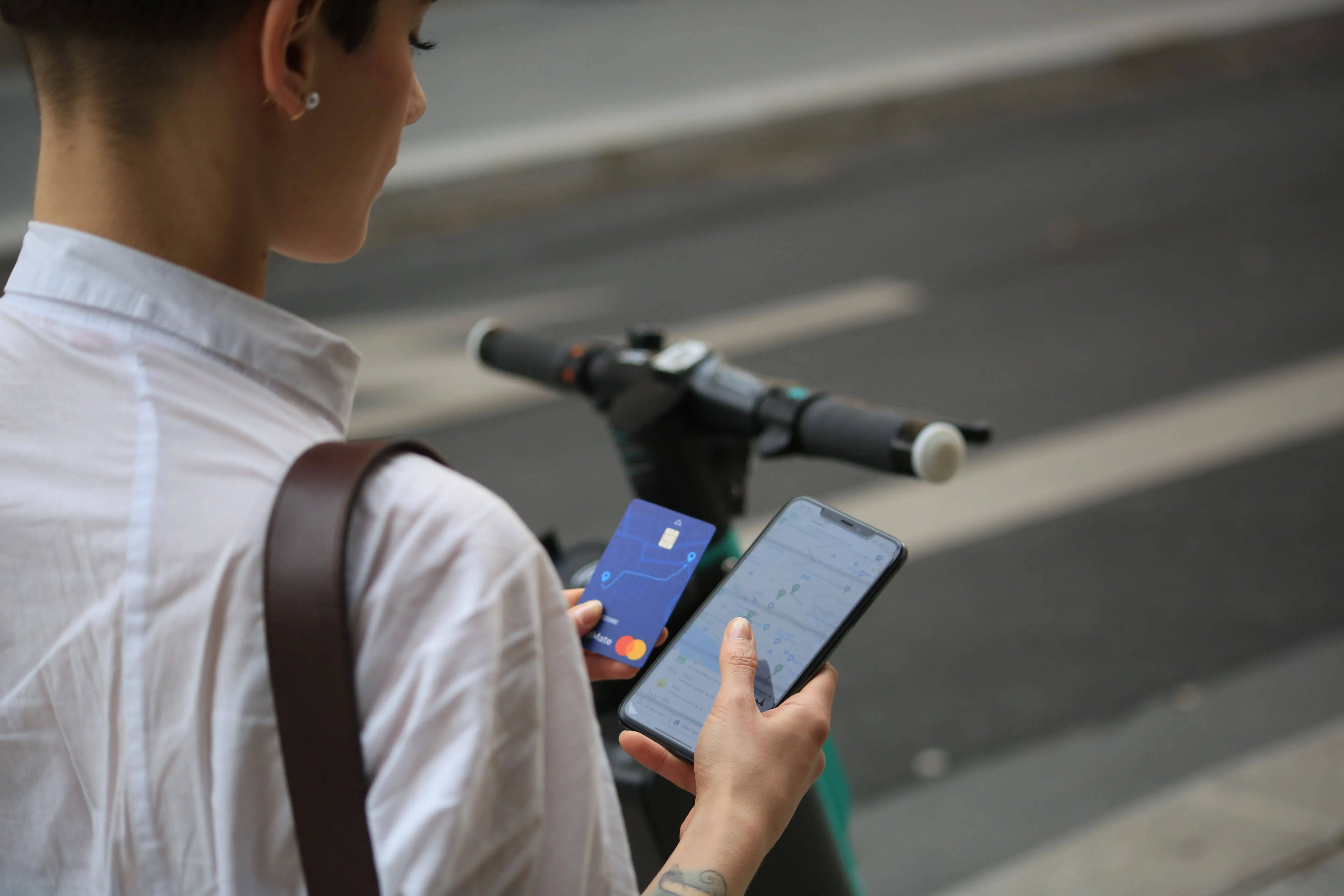 Une utilisatrice utilisant l'application RoadMate et sa carte RoadMate pour choisir une solution de mobilité Une utilisatrice utilisant l'application RoadMate et sa carte RoadMate pour choisir une solution de mobilité